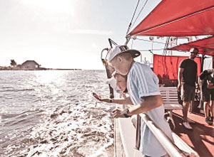 Kinder stehen an der Reling eines Bootes und schauen aufs Wasser.