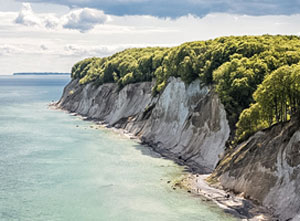 Steilküste mit weißen Kreidefelsen und blauem Meer.